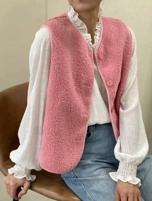 le gilet sans manche rose clair porté sur une chemise blanche 