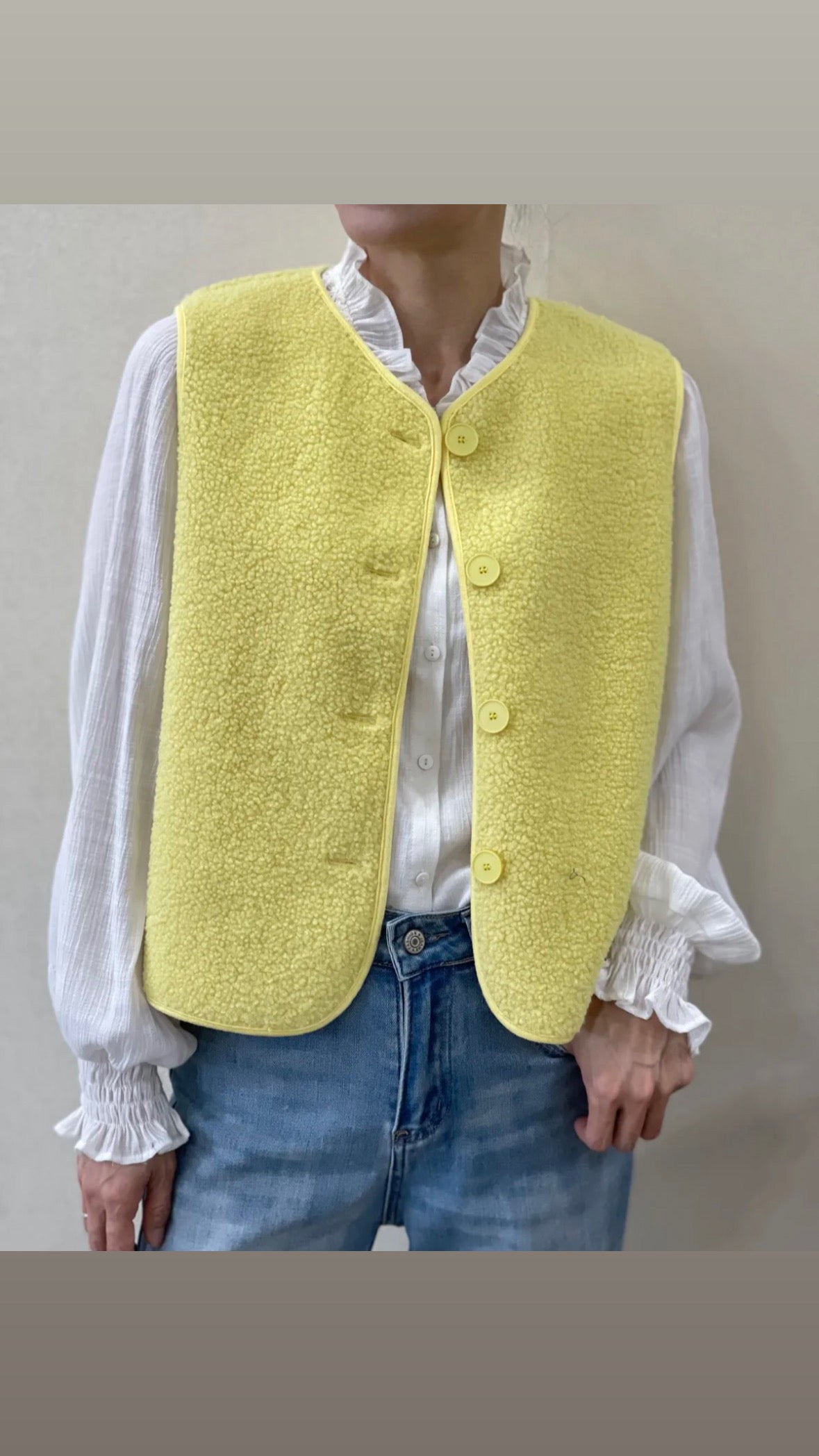 gilet sans manche jaune clair entièrement boutonné devant 